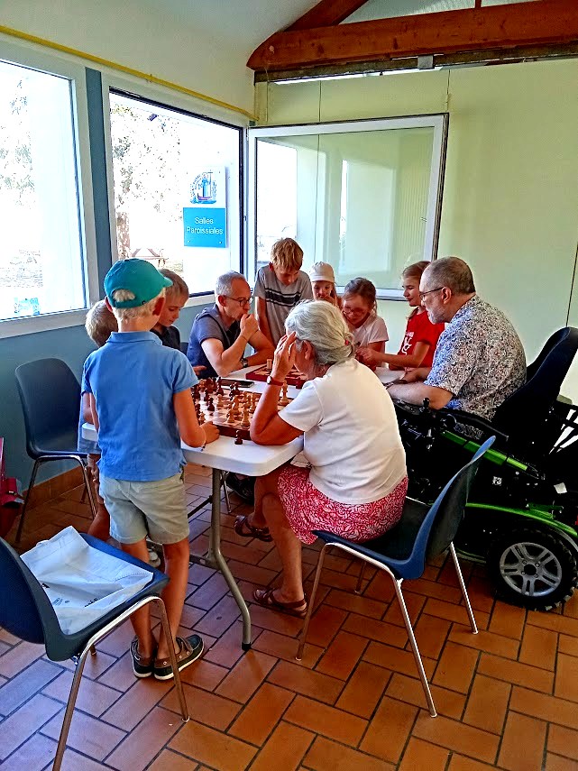 Enfants et adultes réunis autour d’une table dans une salle lumineuse